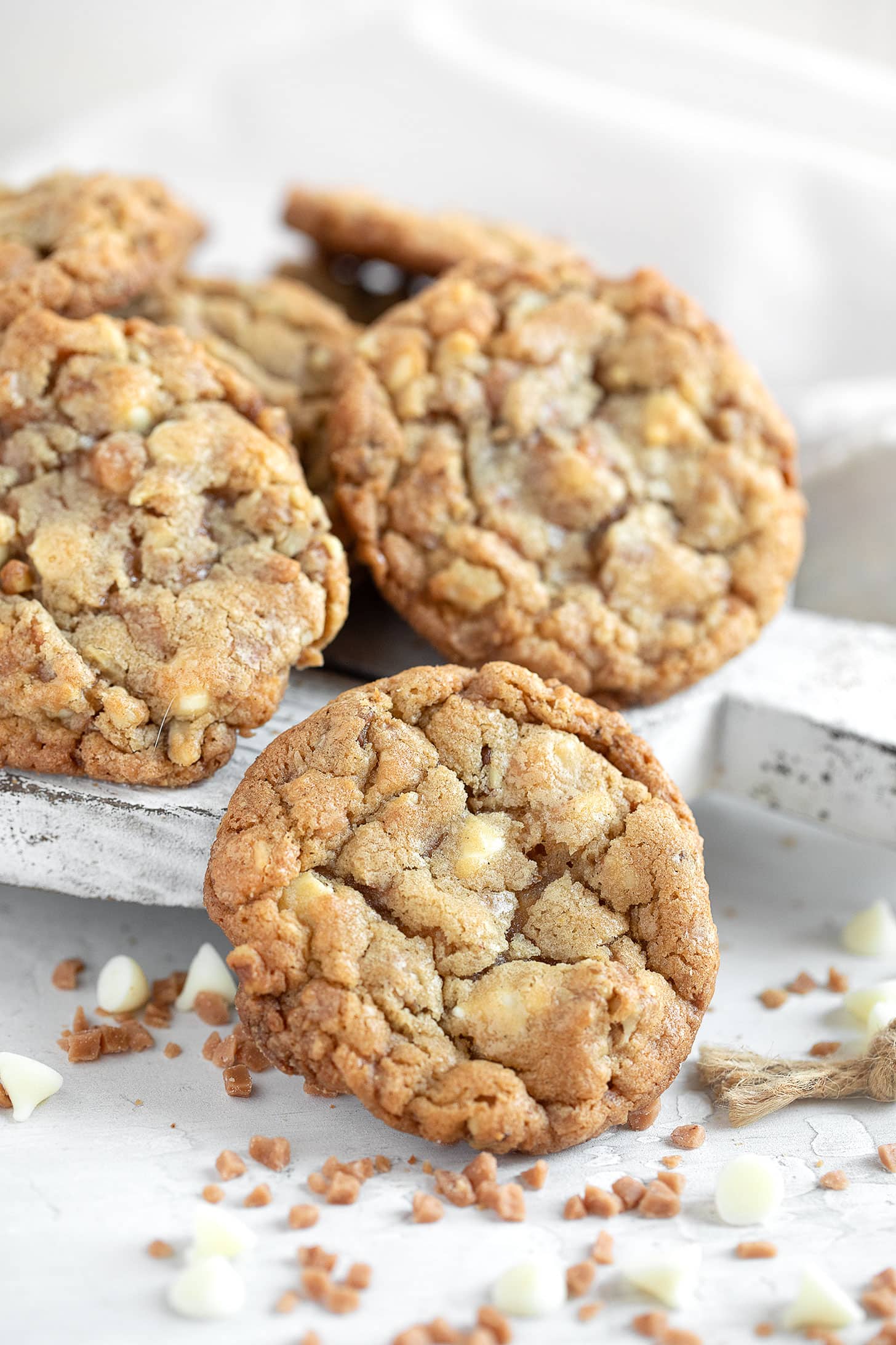 Toffee, walnut and white chocolate cookies on serving board.