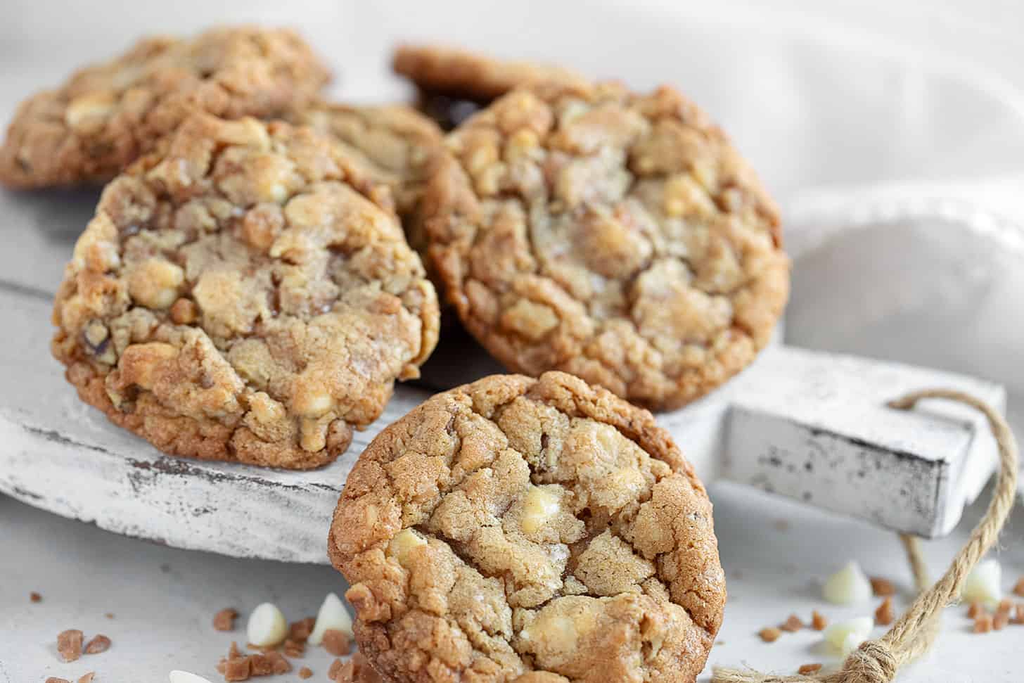 Toffee, walnut and white chocolate cookies on serving board.