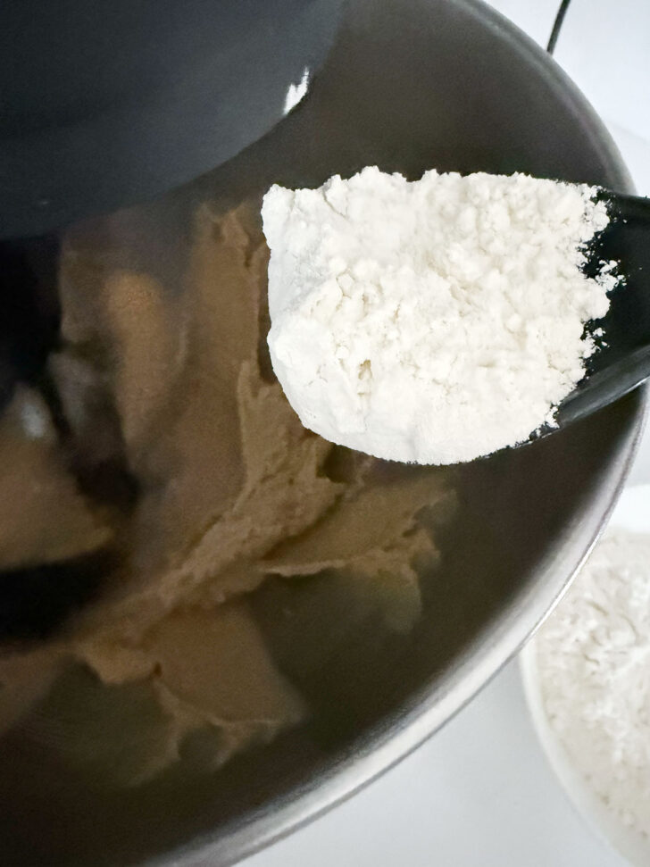 Adding the flour mixture to the cookie dough.