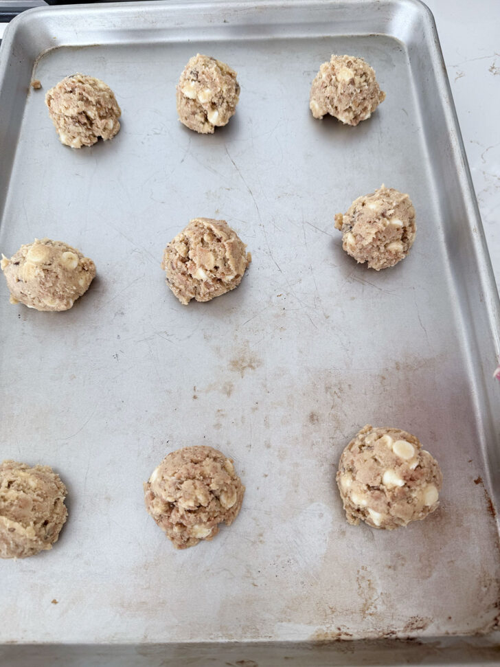 Cookie dough balls on a baking sheet.