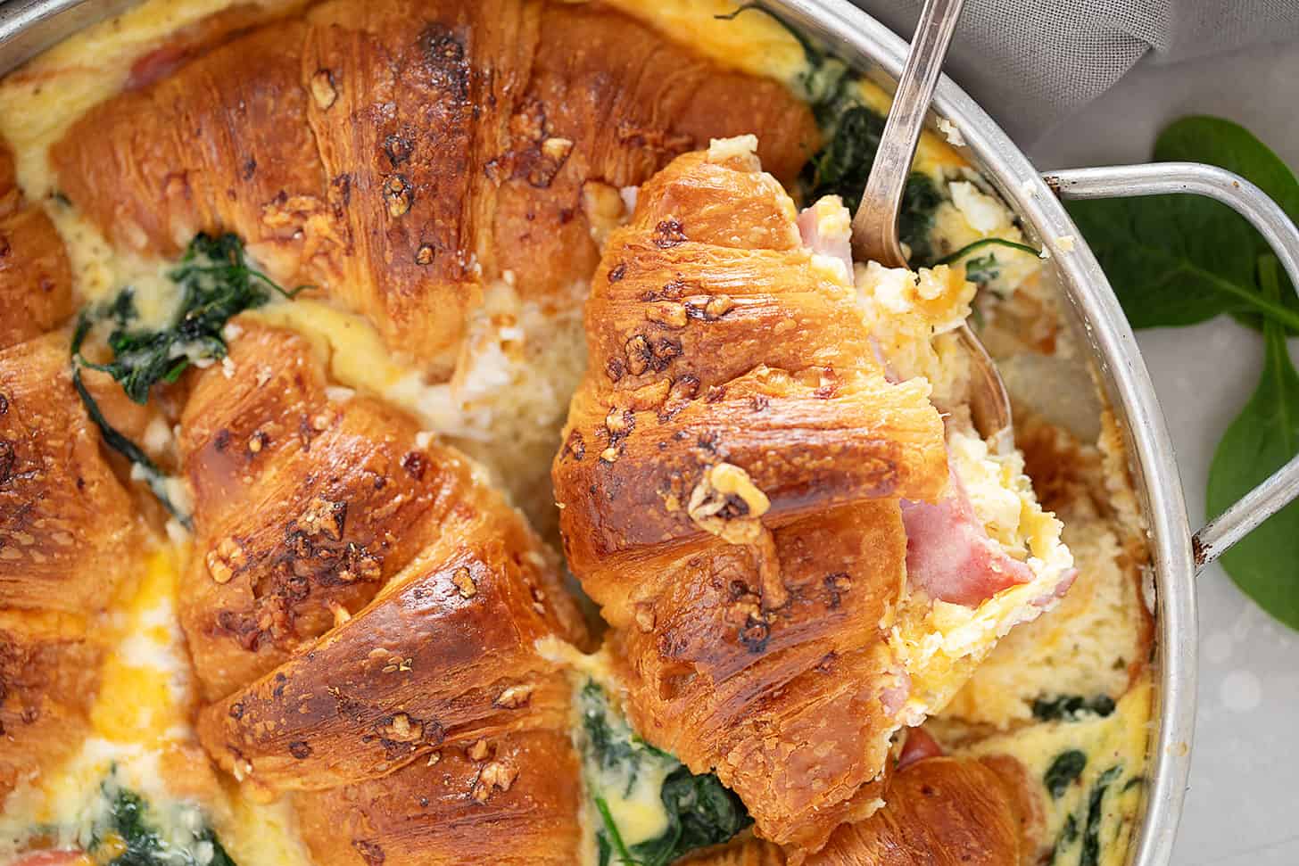 Ham and cheese croissant bake in pan.