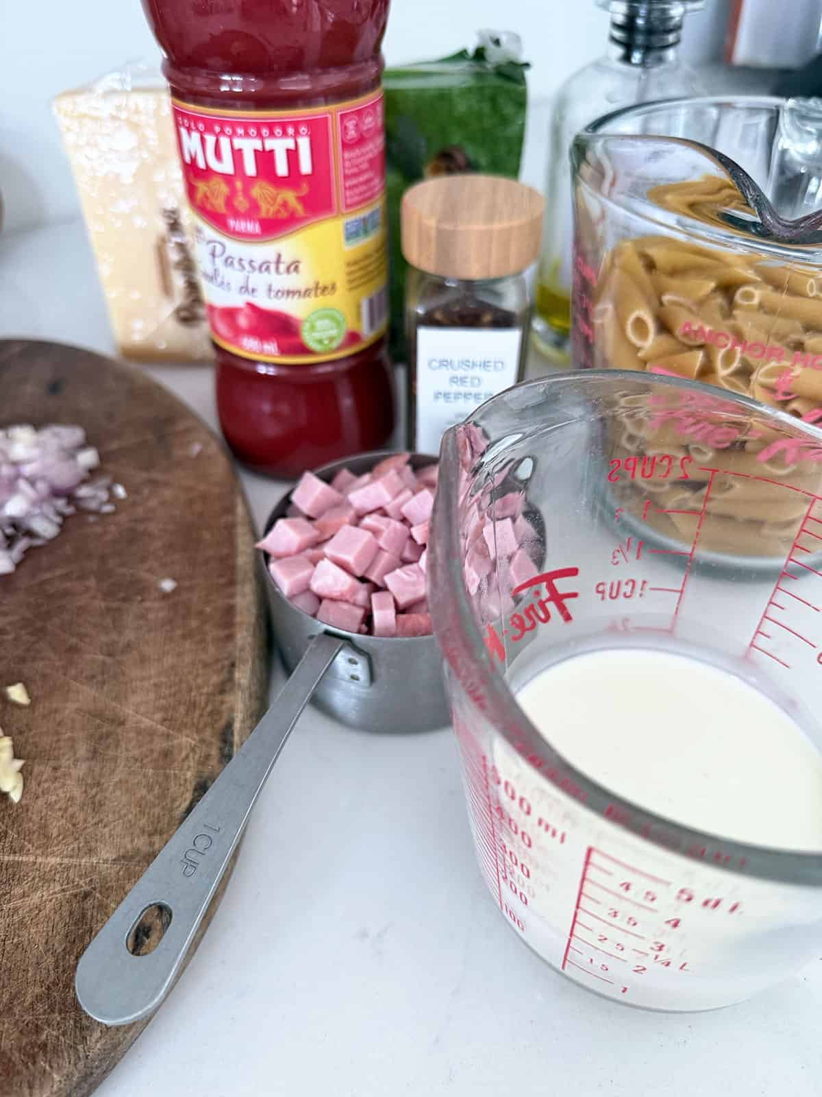 Ingredients gathered for ham and tomato pasta.
