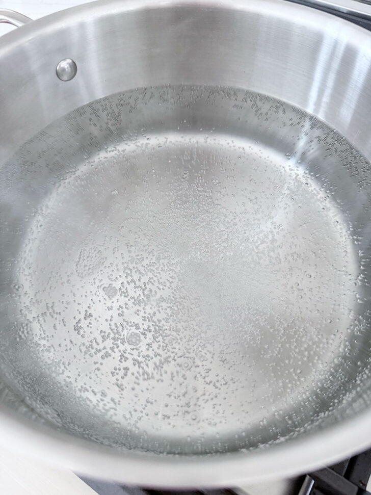 Water in a large pot coming to a boil.
