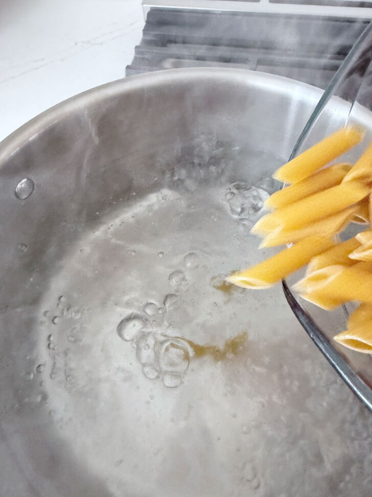Adding the pasta to boiling water.