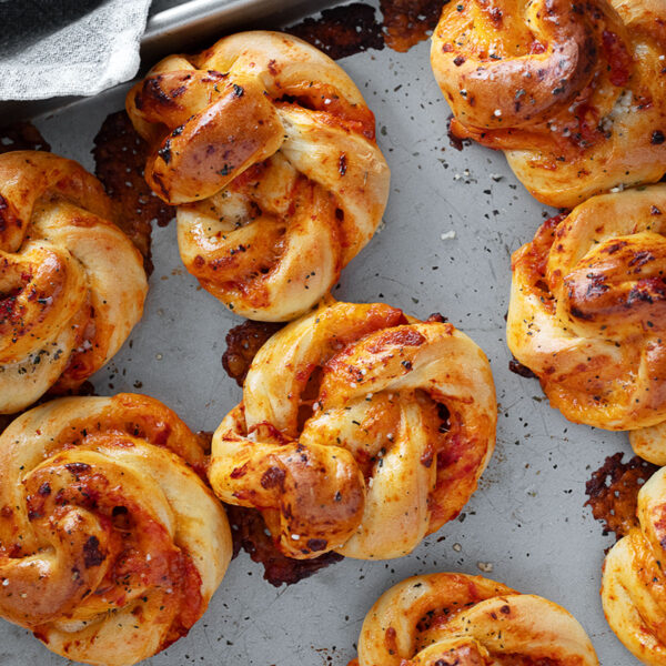 Pizza twists on a baking sheet.