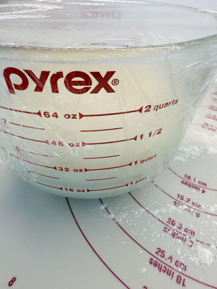 Dough after rising in a large measuring cup.
