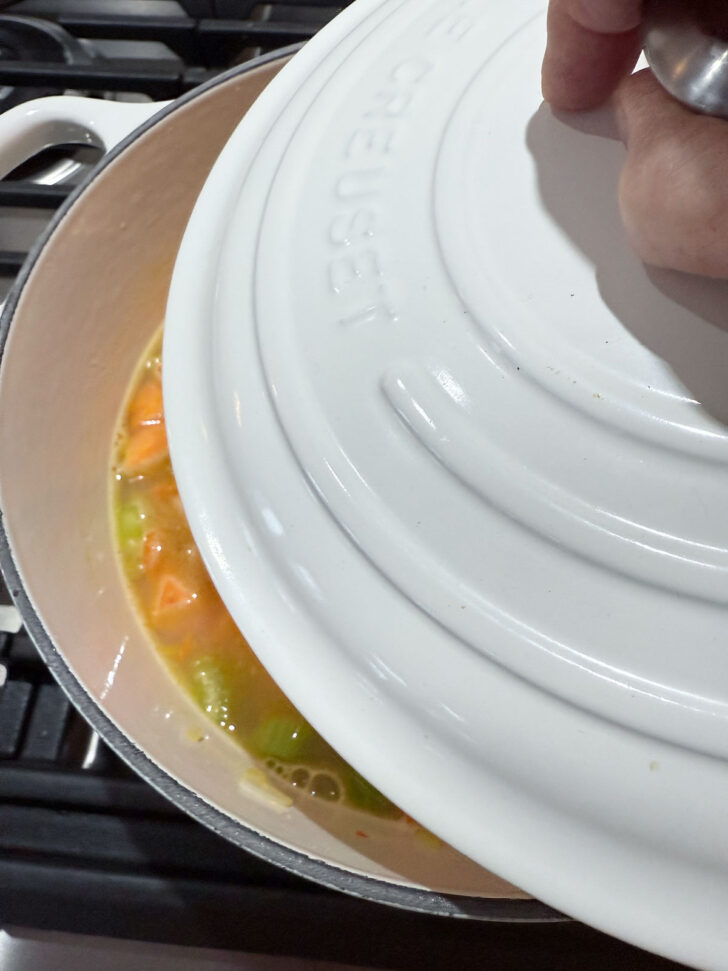 Covering the soup pot to cook the vegetables,