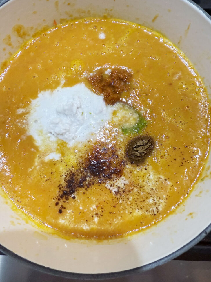 Adding spices and lemon zest to the soup.