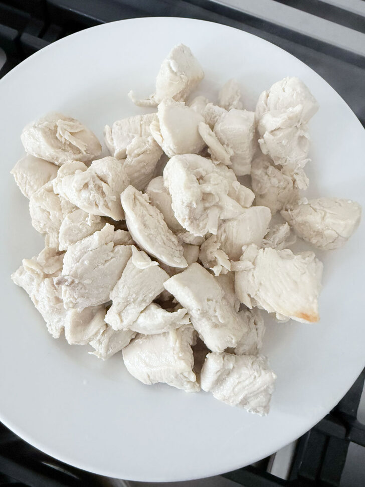 Cooked chicken pieces removed to a plate.