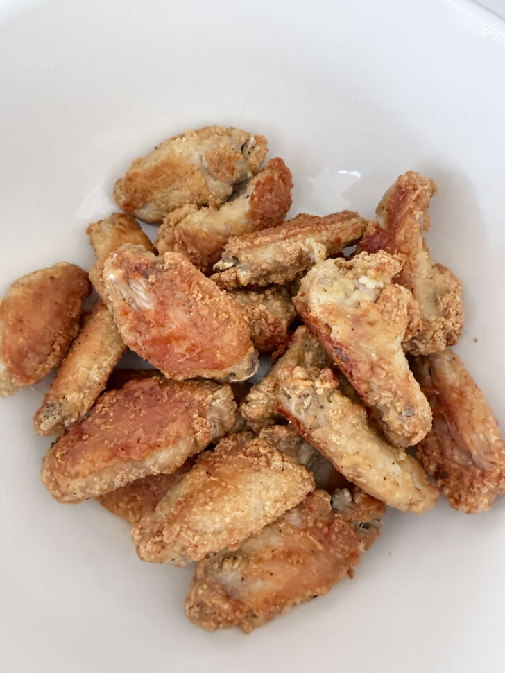 Cooked chicken wings in a bowl.