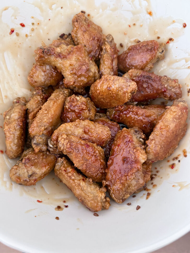 All-dressed saucy chicken wings after tossing in sauce.