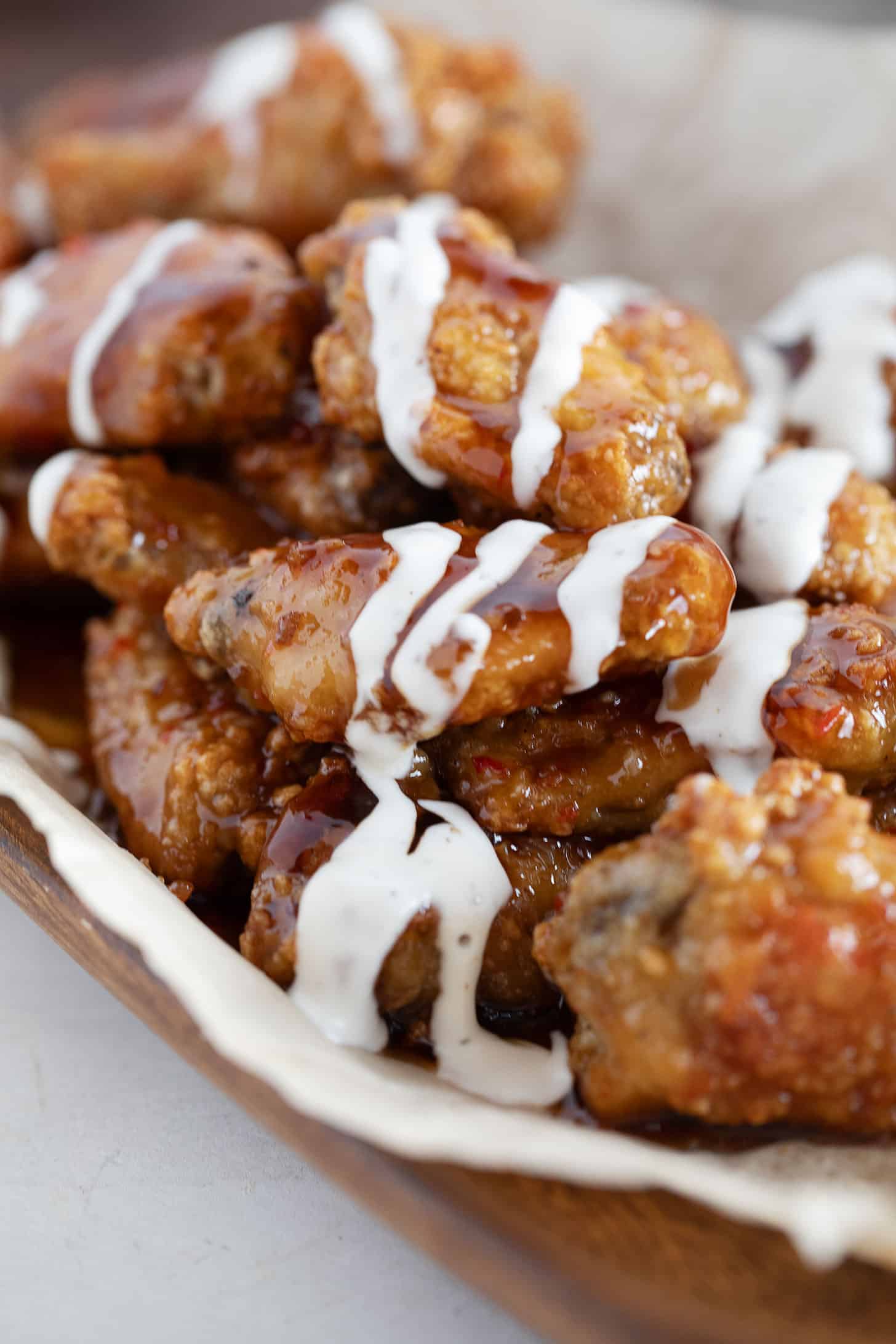 All-dressed saucy chicken wings in a serving bowl.