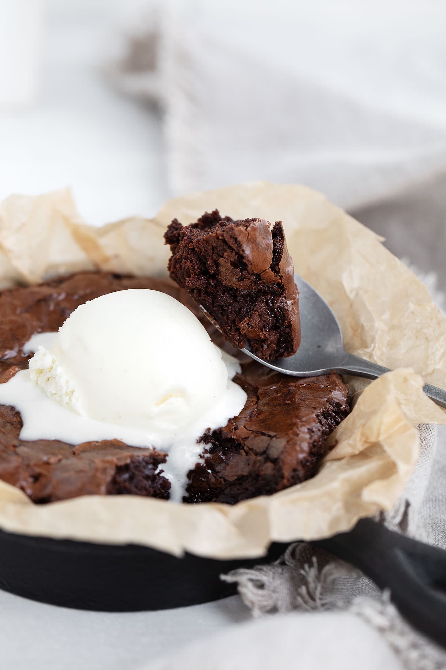 Brownie for two in a small cast iron skillet with ice cream.