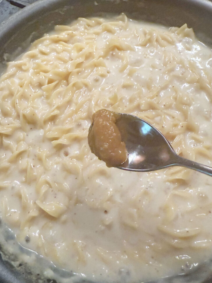 Adding a bit more chicken bouillon to the noodles.