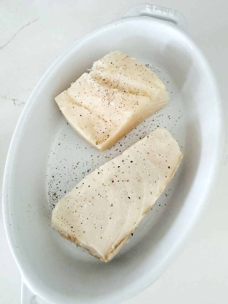 Halibut fillets in a baking dish.