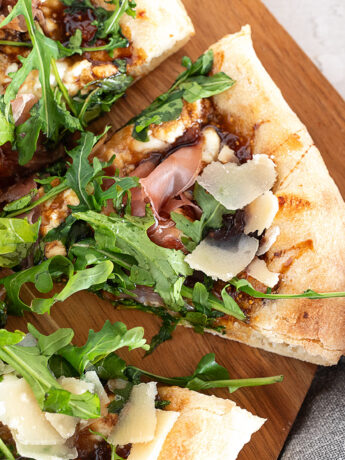 Fig and pig pizza sliced on a pizza peel.