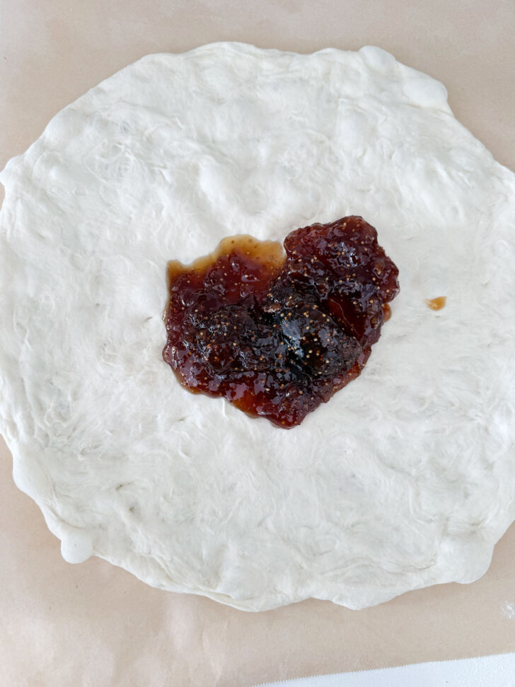 Fig jam spooned onto pizza dough.