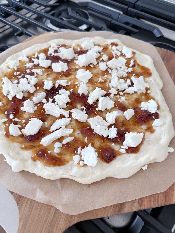 Fig jam and goat cheese on the pizza dough, ready for the oven.