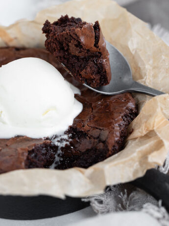 Snacking brownie in a small cast iron skillet.