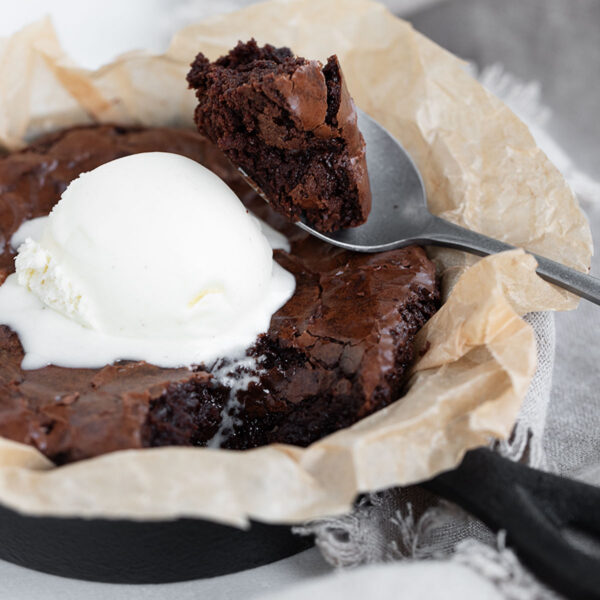 Snacking brownie in a small cast iron skillet.