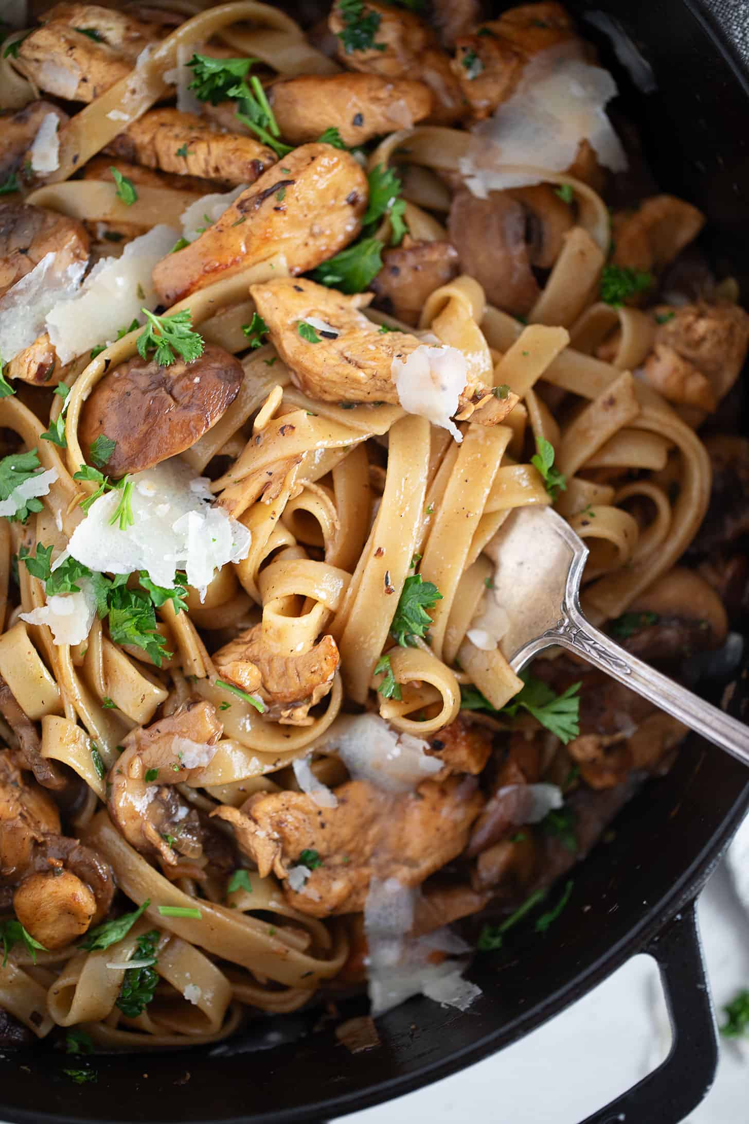 Chicken marsala pasta in a skillet with a fork.