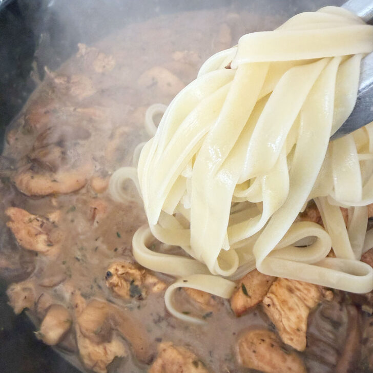 Cooked pasta is being added to the Marsala mushroom sauce.