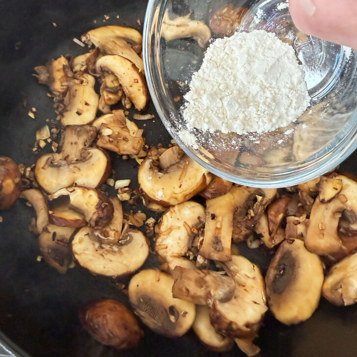 Adding flour to the cooked mushrooms and shallots.