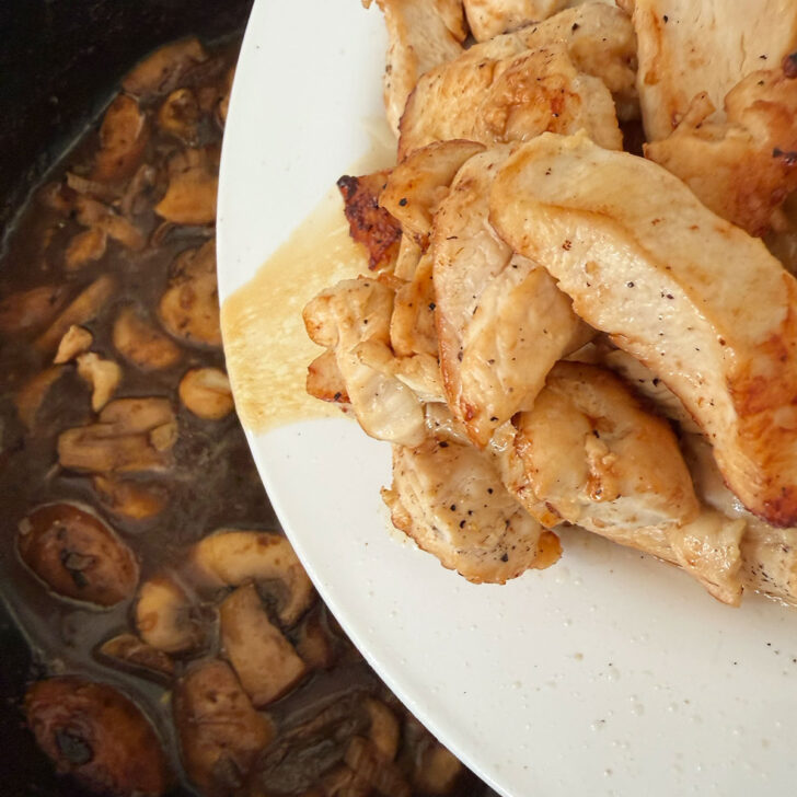 Returning the chicken breast pieces to the skillet.