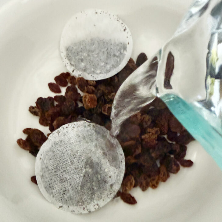 Adding boiling water to raisins and earl grey tea bags.