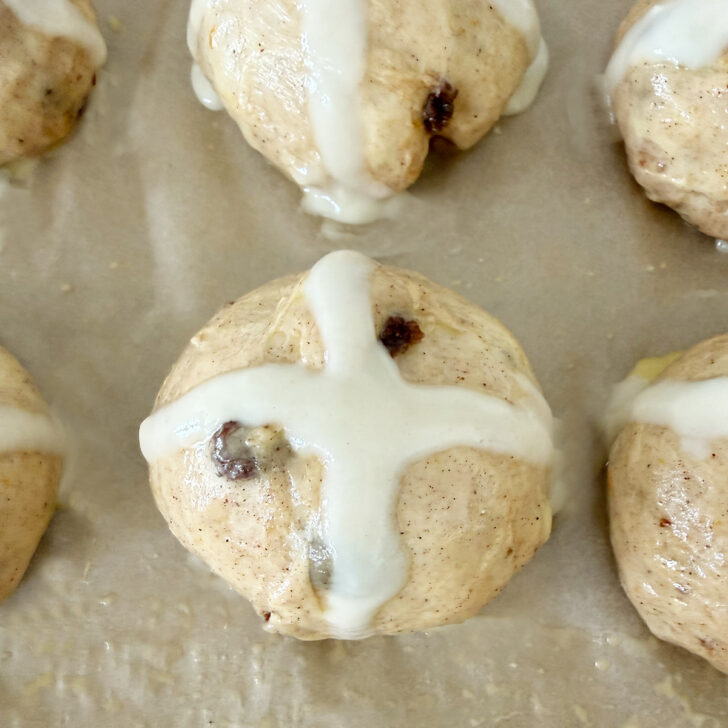 Buns after piping the flour cross on top.