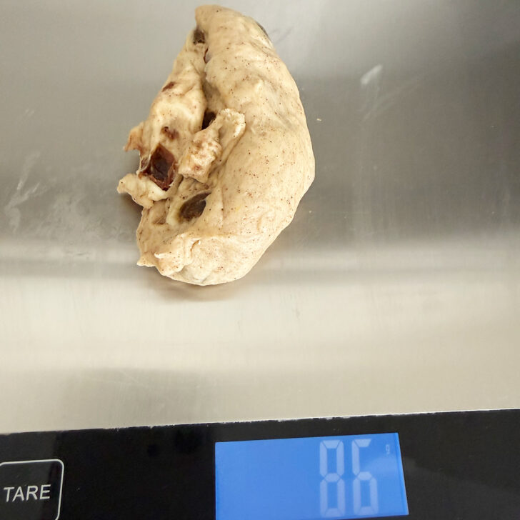 Weighing out the dough balls on a scale.