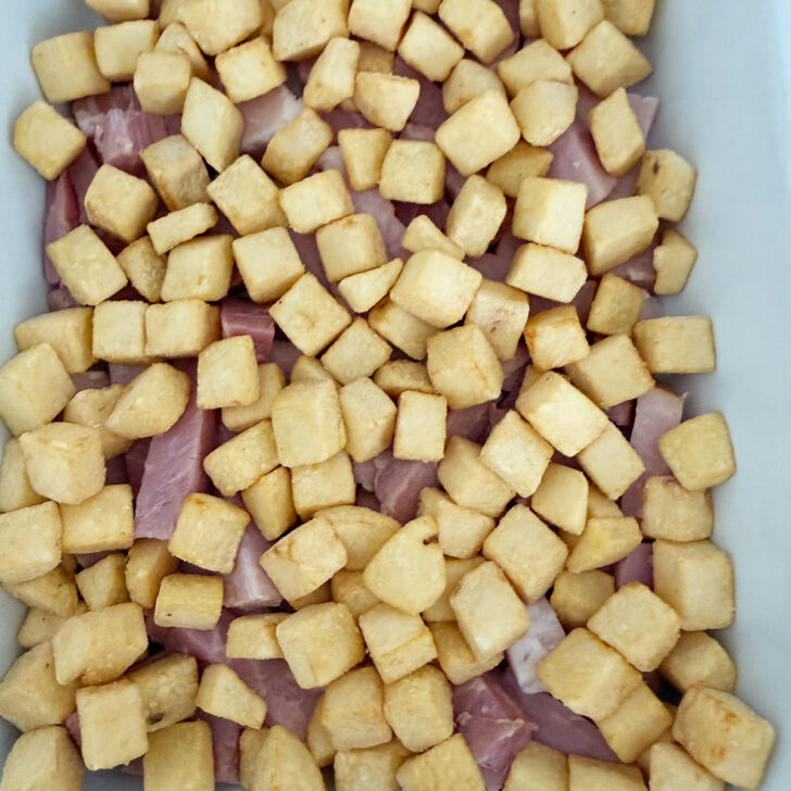 Ham and hash browns added to the casserole dish.