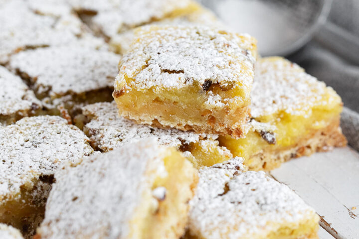 Lemon pistachio shortbread squares cut on a serving board.