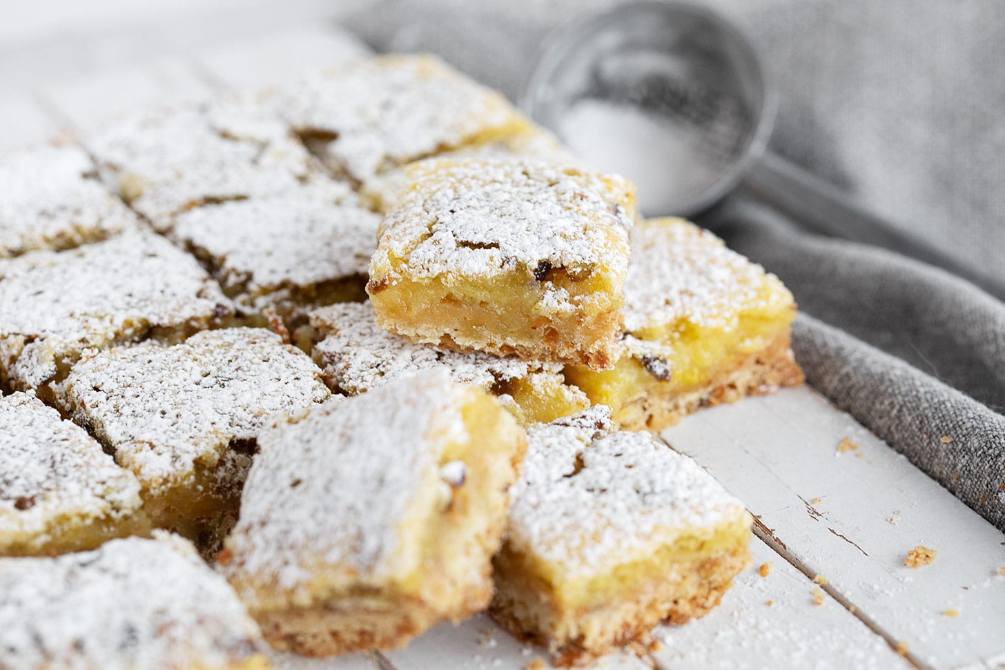 Lemon pistachio shortbread squares cut on a serving board.