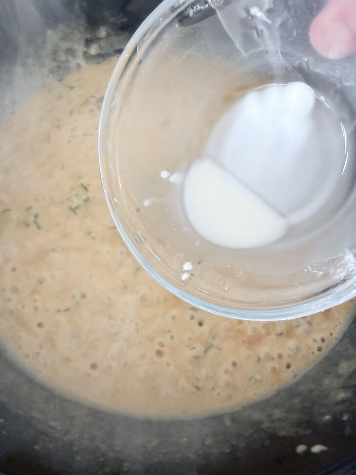Thickening the sauce with cornstarch and water.