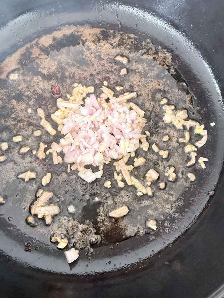 Garlic and shallot cooking in a skillet.