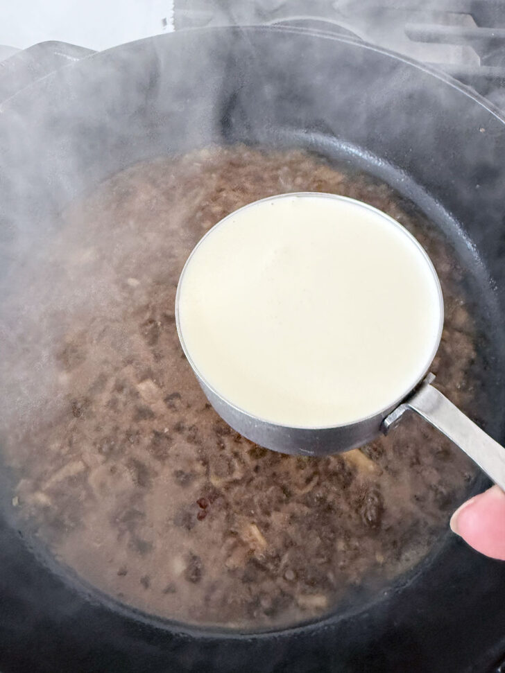Adding the cream to the skillet.