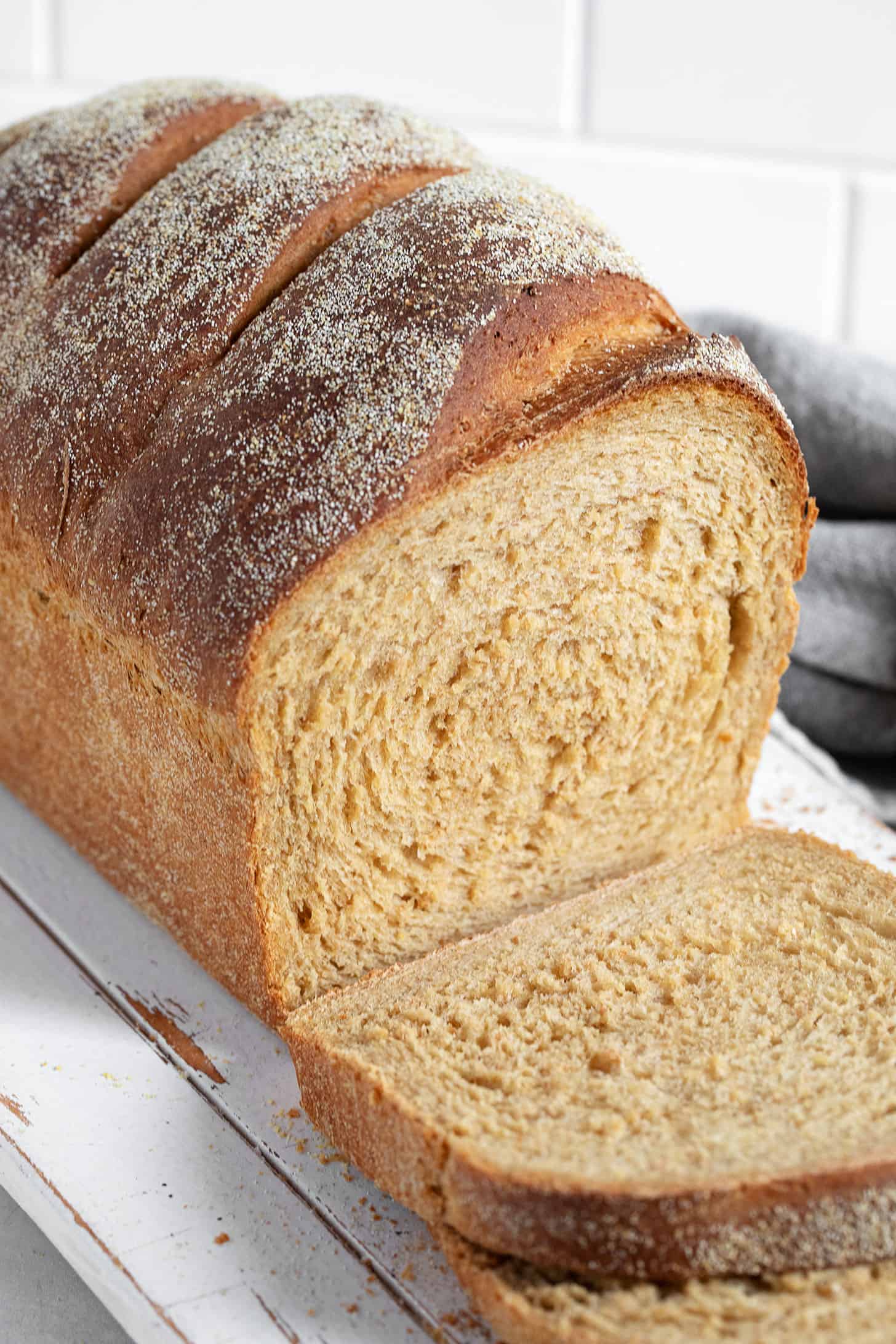 Anadama bread sliced on a cutting board.
