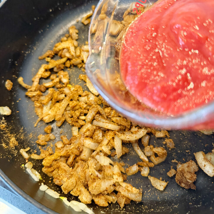 Add the tomato passata and broth to the skillet.
