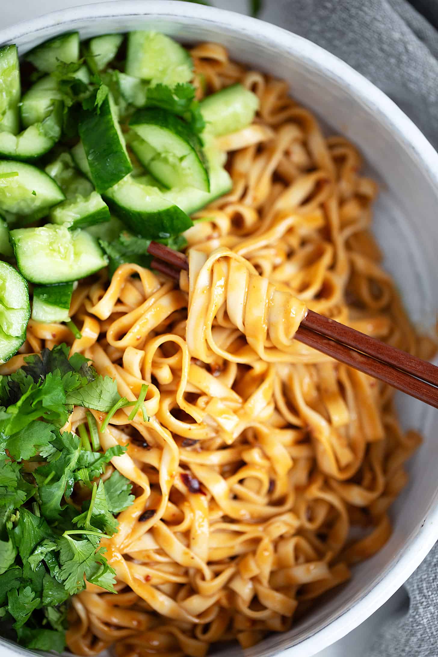 Málà noodles in serving bowl with smashed cucumbers.