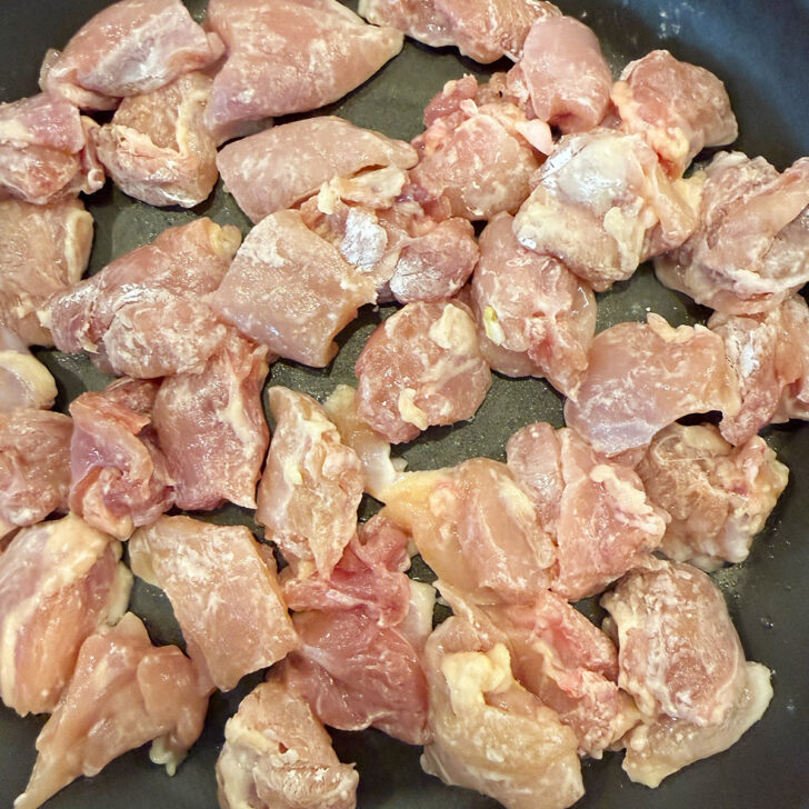 Cooking the chicken pieces in a skillet.