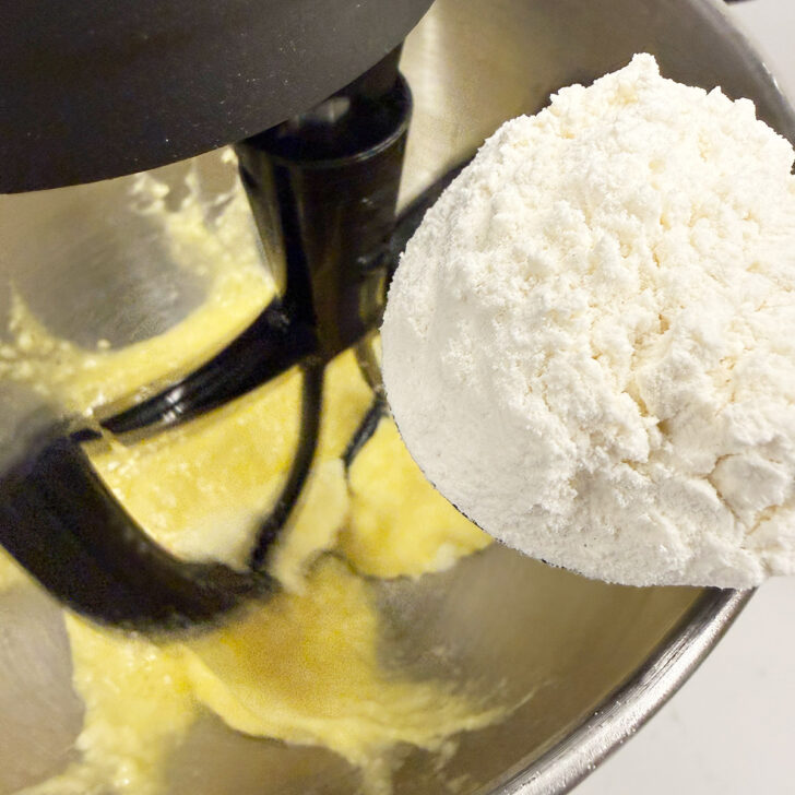Adding flour to the cake batter.