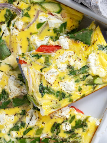 Sheet pan asparagus frittata cut in the pan.