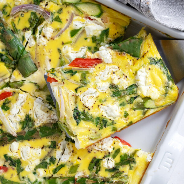 Sheet pan asparagus frittata cut in the pan.