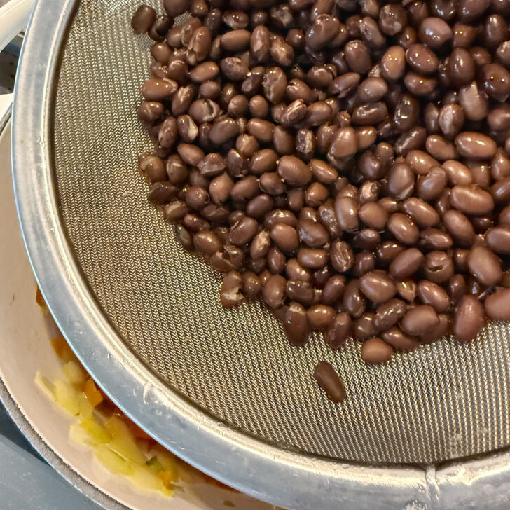 Adding the black beans to the chili.