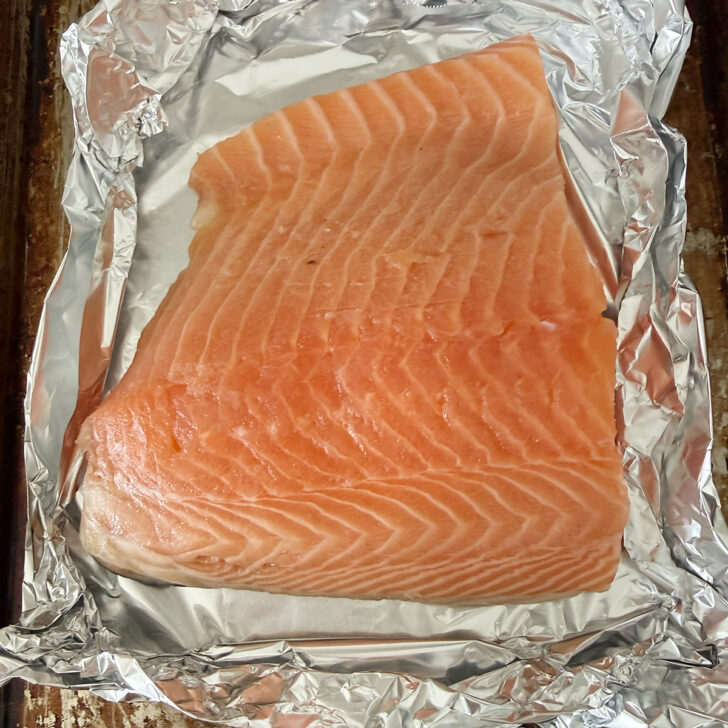 Salmon on a foil-lined baking sheet.