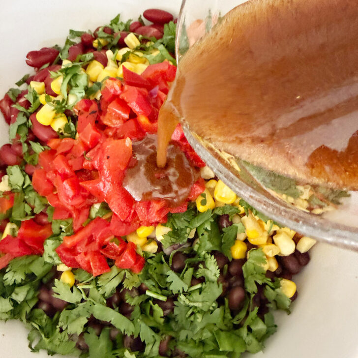 Adding the dressing to the salad.