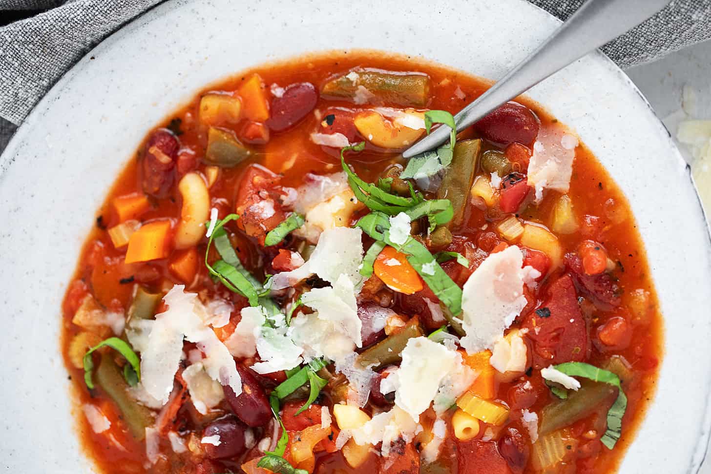 Classic minestrone soup in a bowl with a spoon.