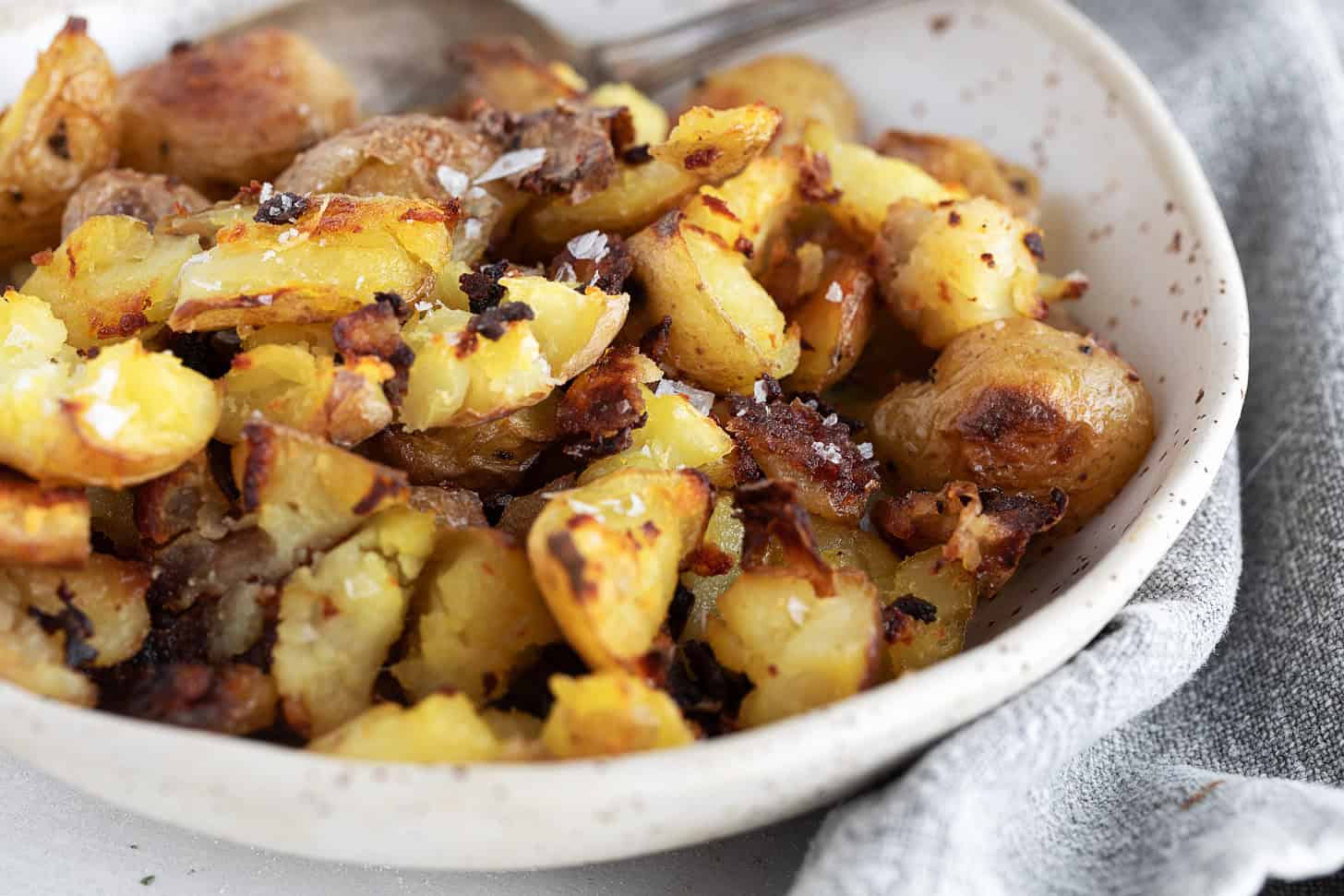 Salt and vinegar flavoured oven-roasted potatoes in a bowl.