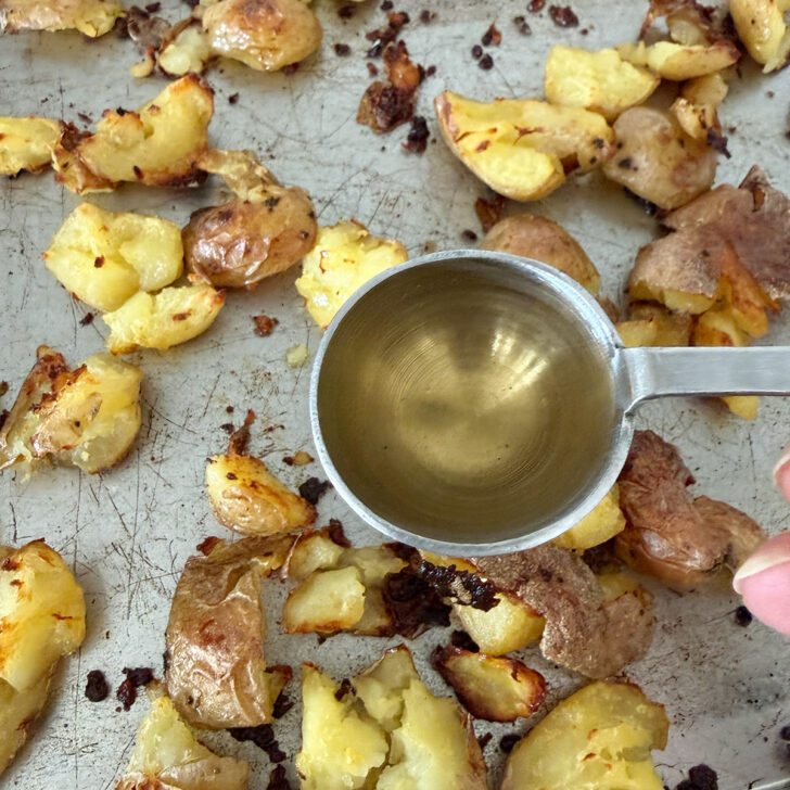 Drizzling vinegar over the hot roasted potatoes.